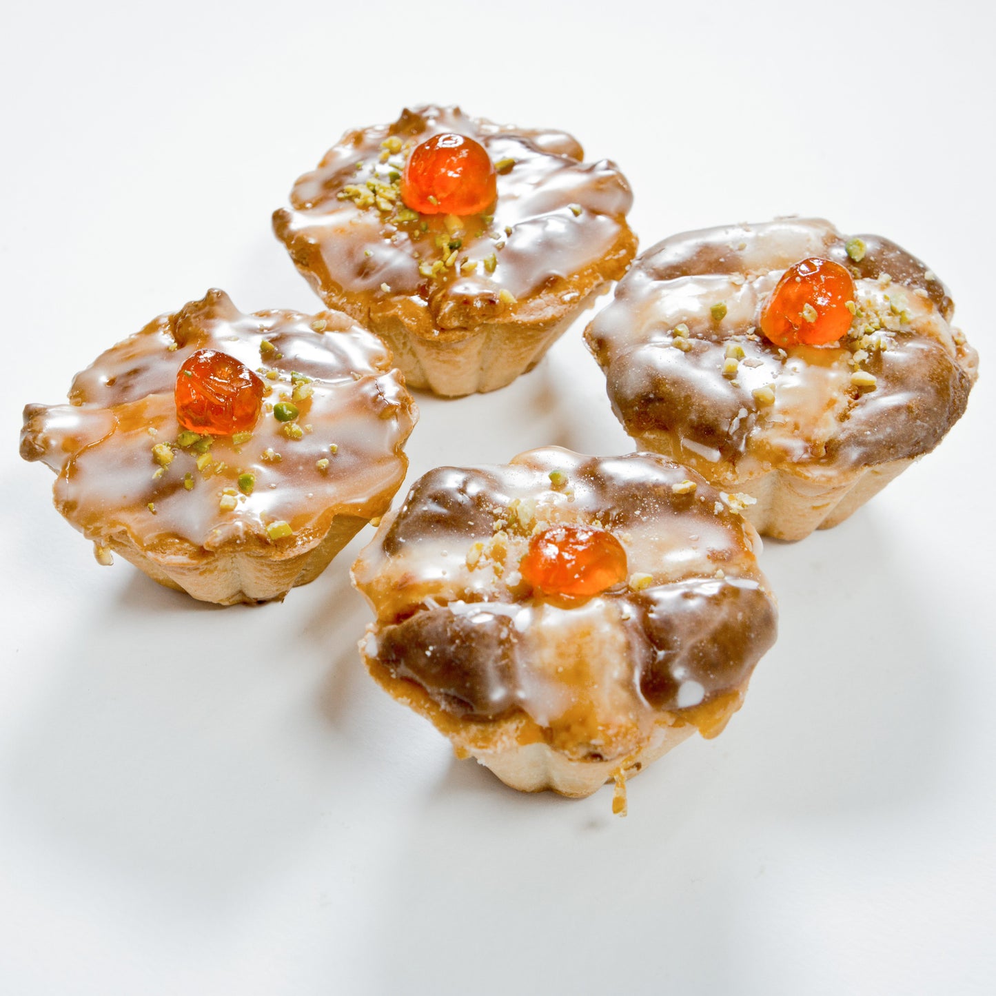 Vier Marzipantörtchen aus feinen Backwaren, appetitlich präsentiert, vom Onlineshop der Bäckerei Sailer.