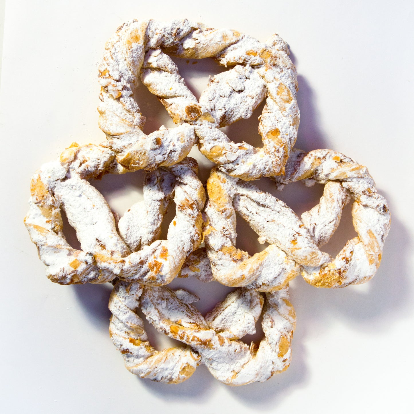 Vier frisch gebackene Olgabrezeln aus feinen Backwaren, perfekt zum Snack, auf einem Teller im Onlineshop der Bäckerei Sailer