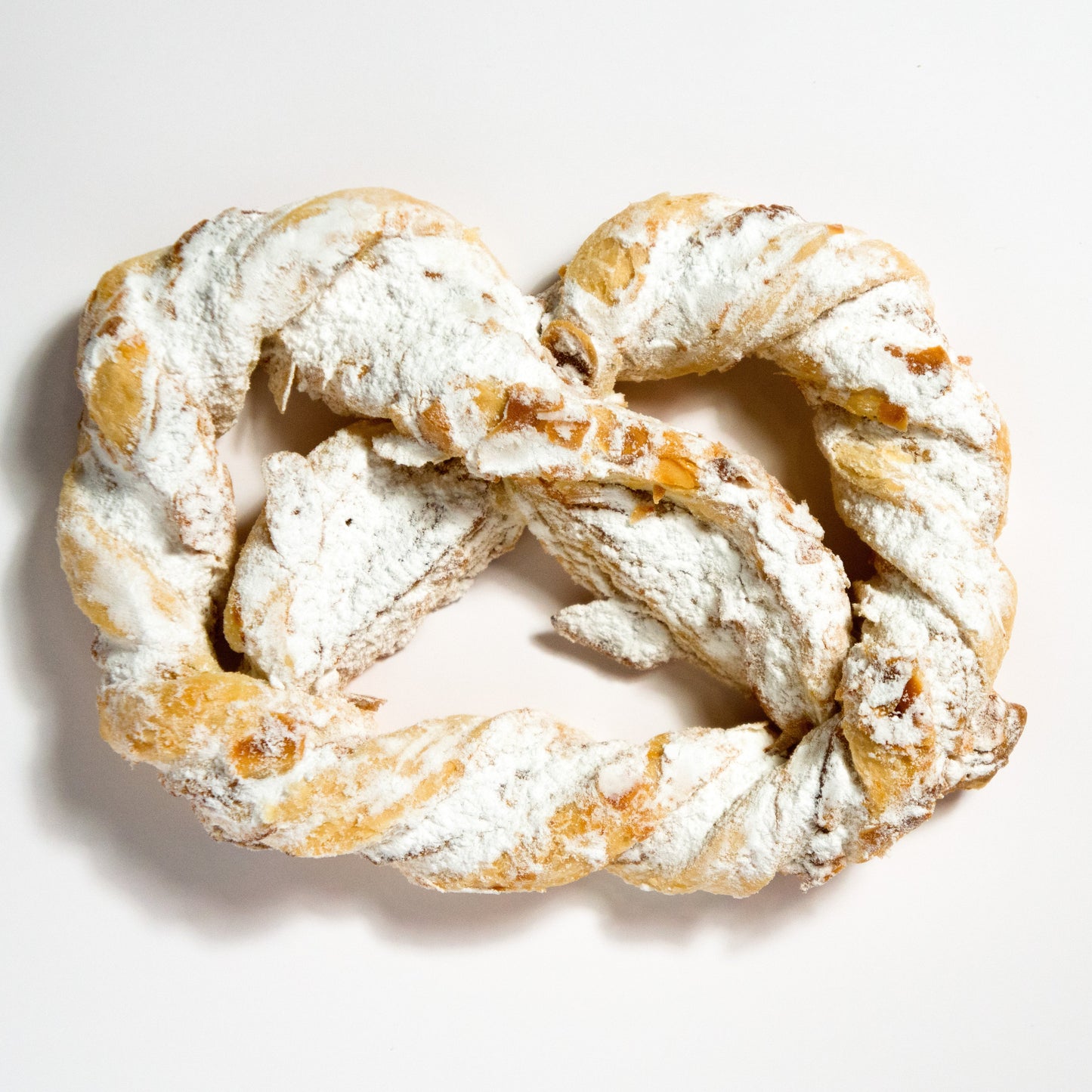 Vier frisch gebackene Olgabrezeln aus feiner Backware, präsentiert in einem 4er-Pack, vom Onlineshop der Bäckerei Sailer.