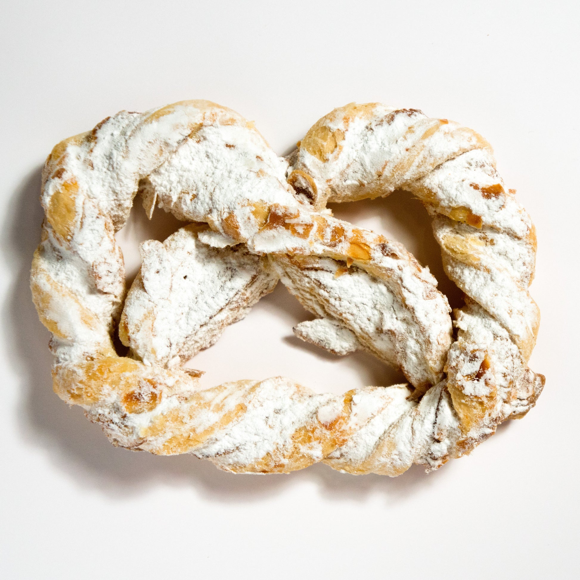 Vier frisch gebackene Olgabrezeln aus feiner Backware, präsentiert in einem 4er-Pack, vom Onlineshop der Bäckerei Sailer.